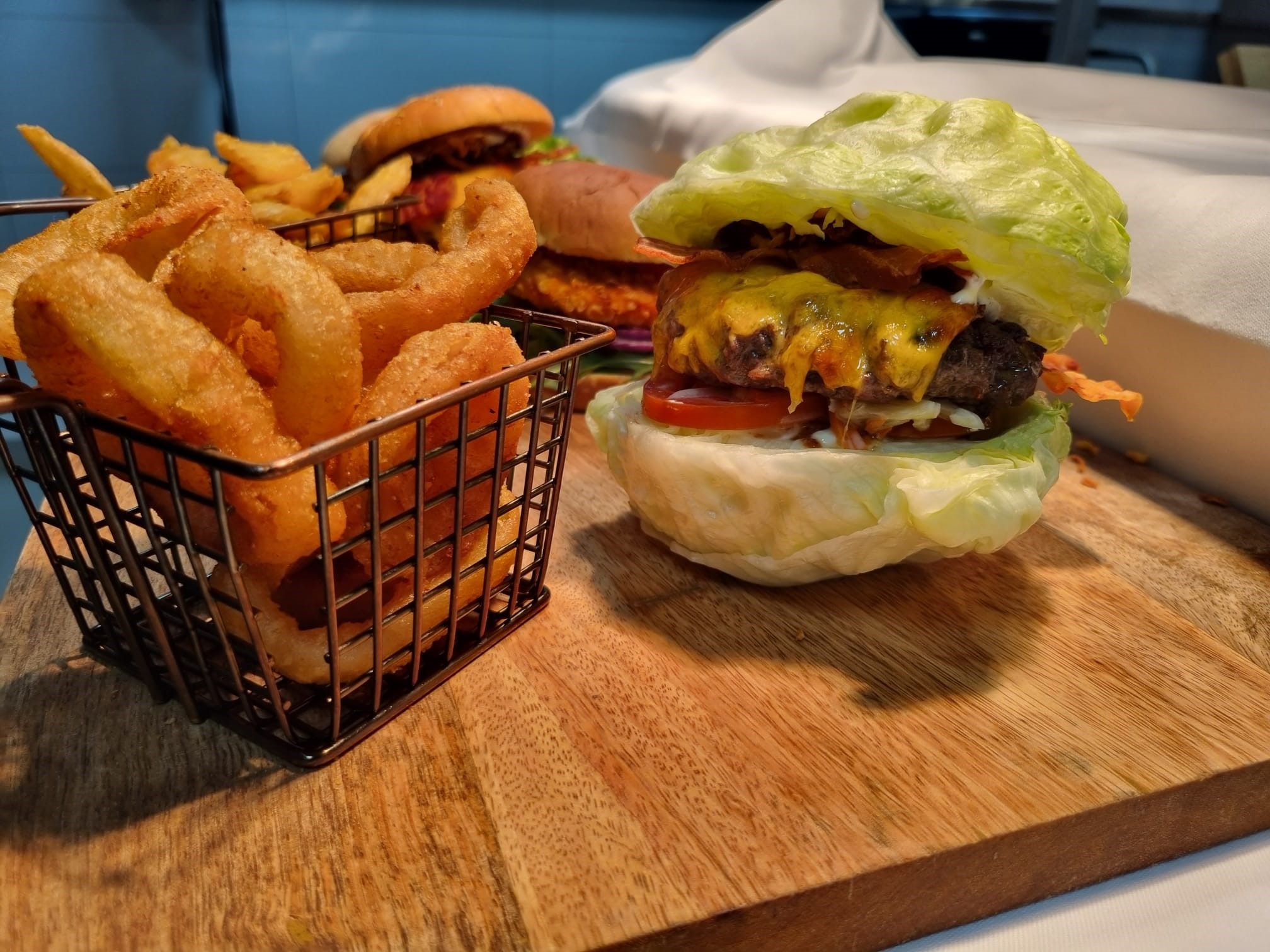 Burger mit Zwiebelringen im Uwe & Uli Burgerladen